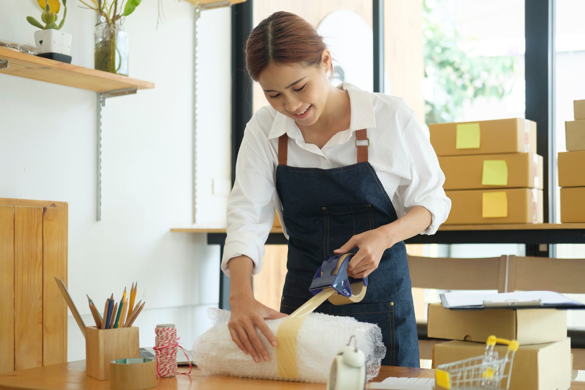 female-online-business-owner-packing-order-box-for-dispatching-.jpg